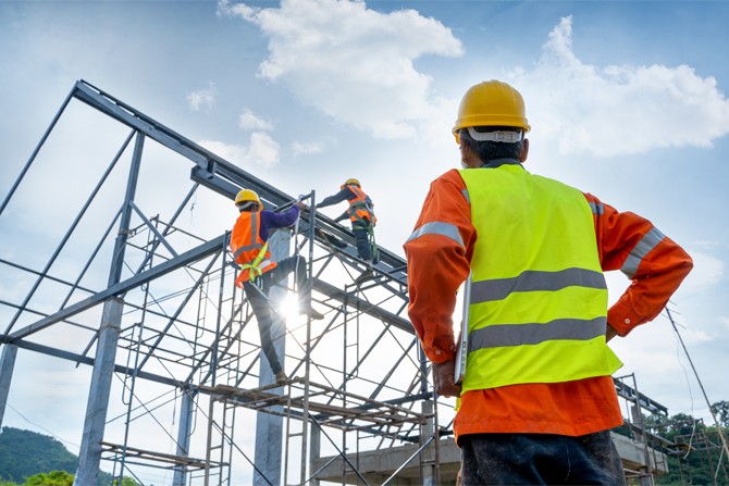 Construction worker looking at a building being built
