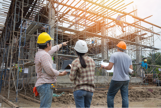 Construction workers looking at a building being constructed